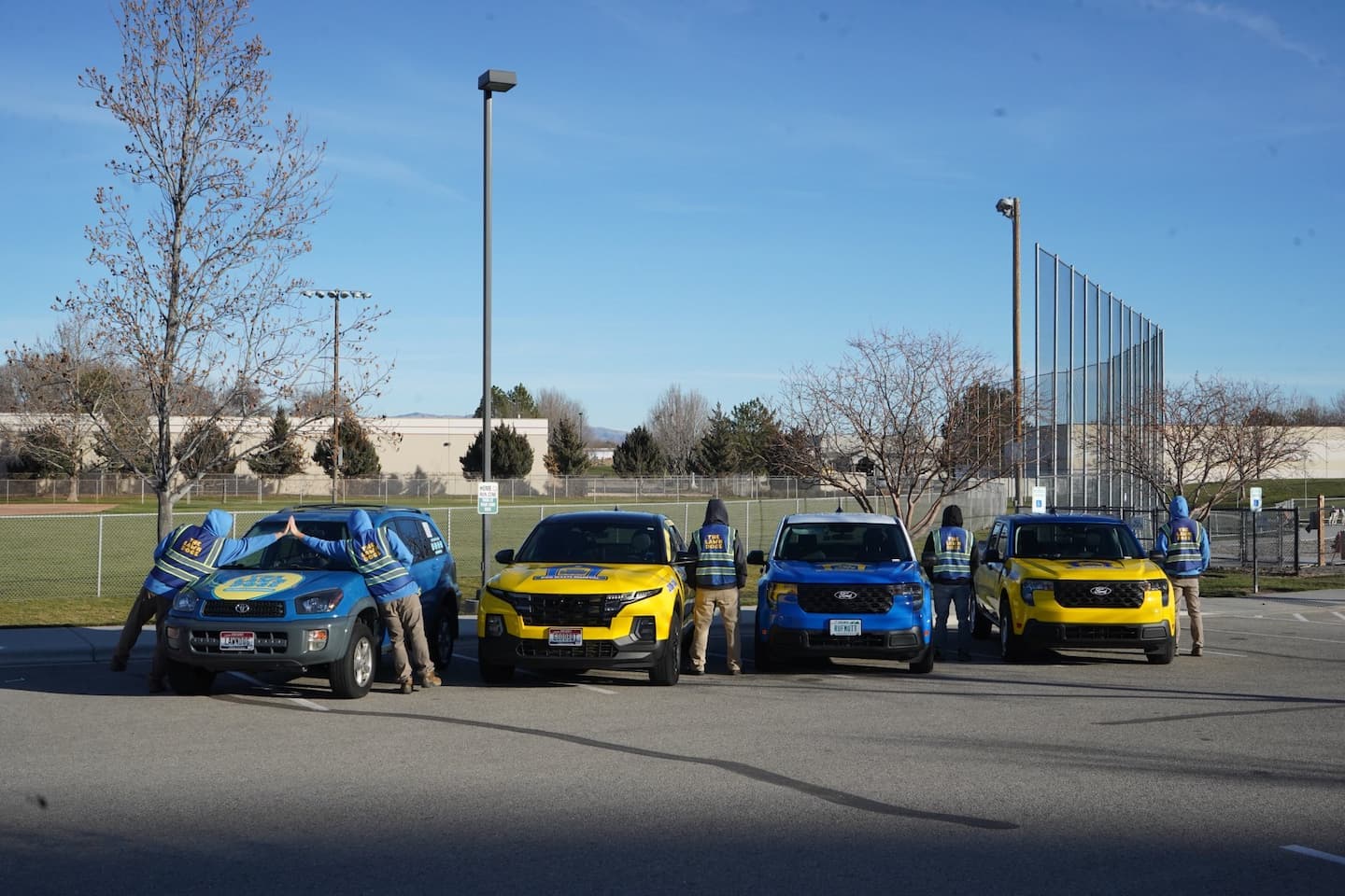 The Lawn Dogs wrapped trucks lined up with technicians in branded uniforms
